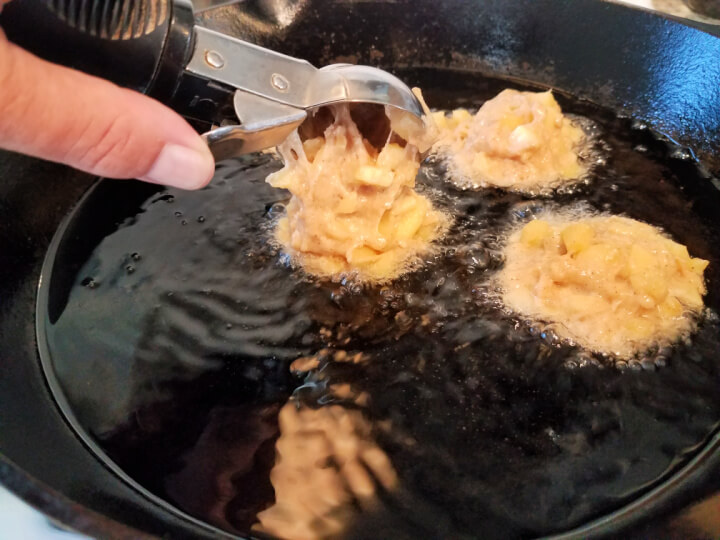 using a cookie scoop to add batter to oil