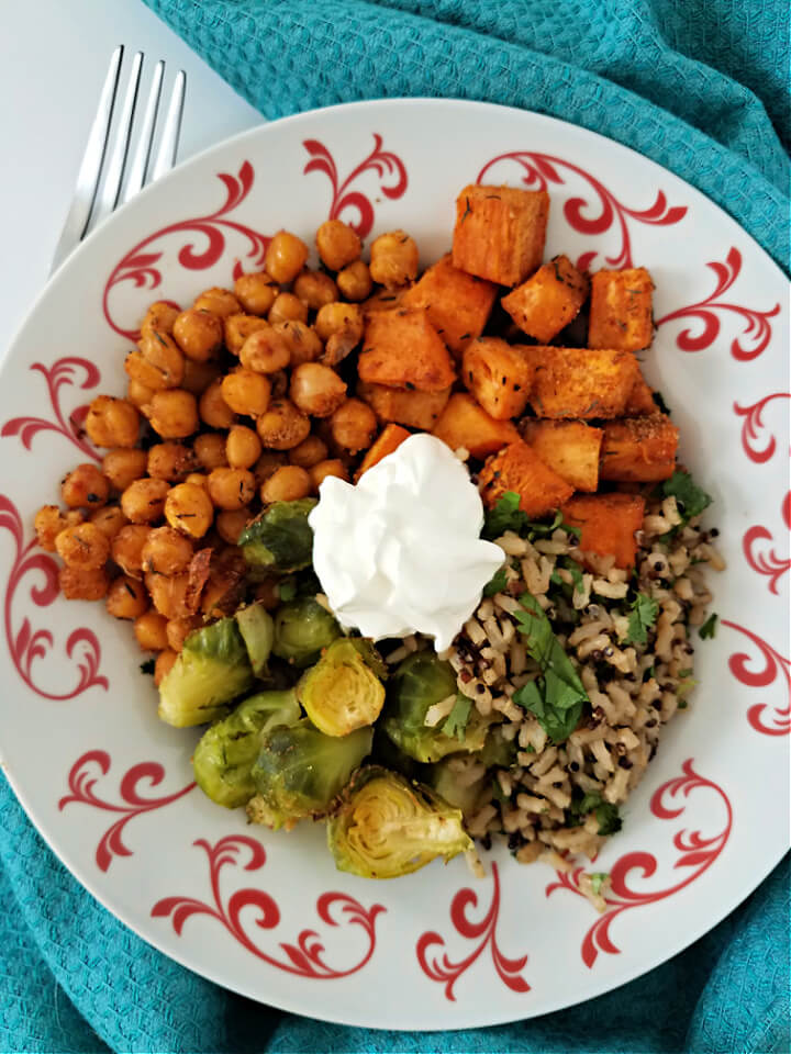 photo of sweet potatoes, chickpeas, brussels sprouts and grains in a bowl